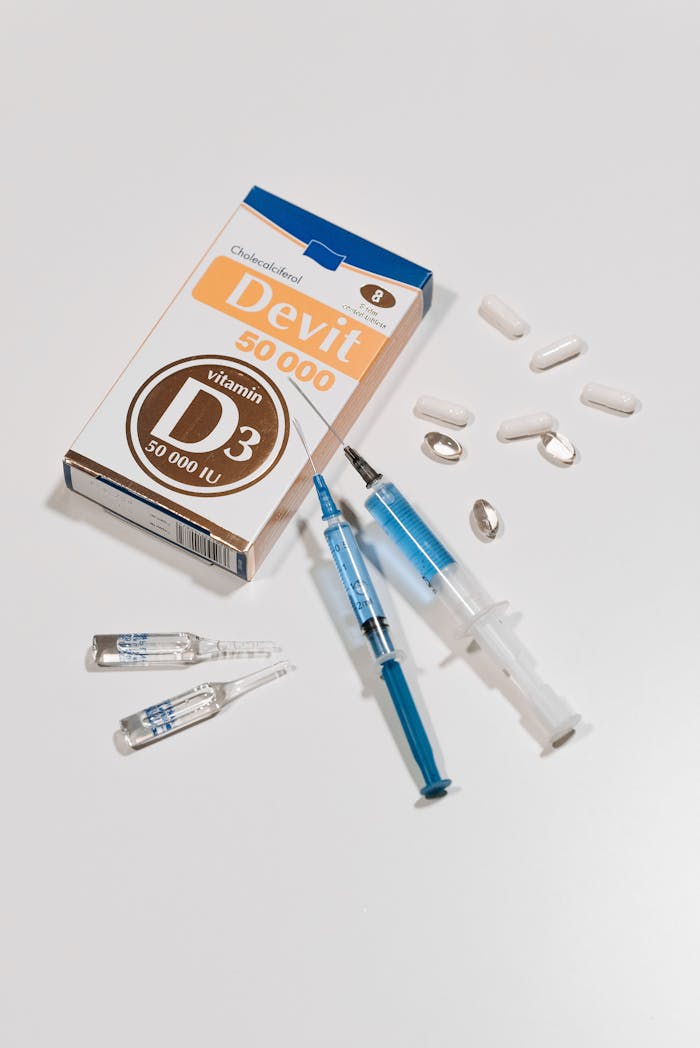 Vitamin D3 supplements, syringes, capsules, and ampoules on a white surface.
